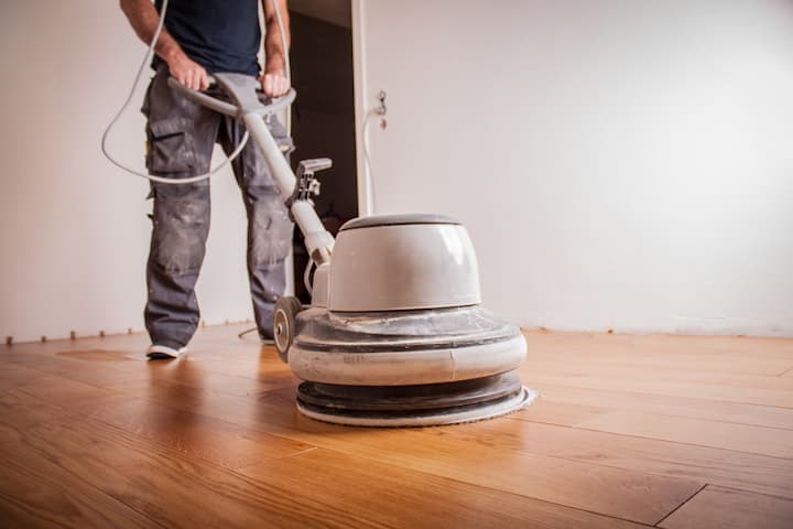 person using machine to buff hardwood floor